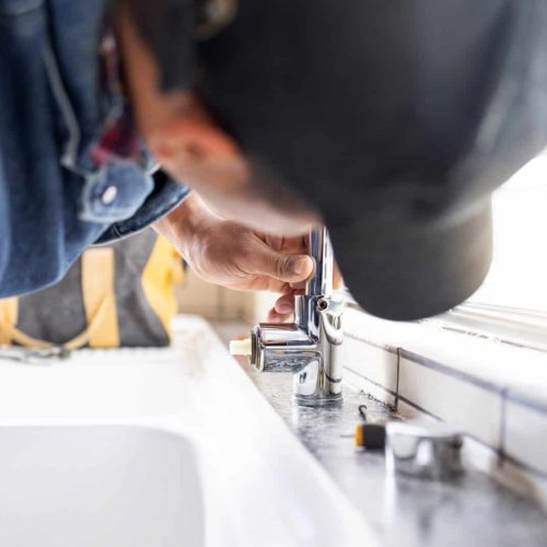 Plumber fixing faucet, plumbing and maintenance with man, manual labour and home renovation with tr